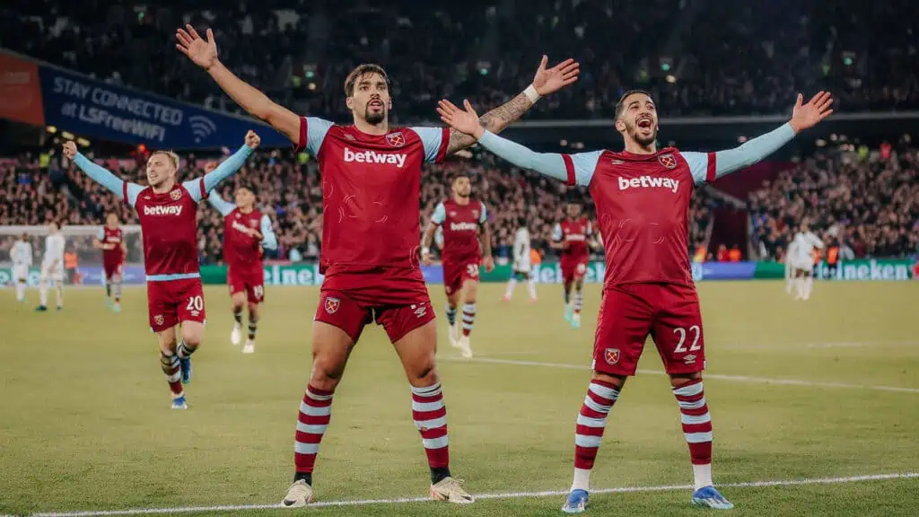 a group of soccer players in red kits pose on the field