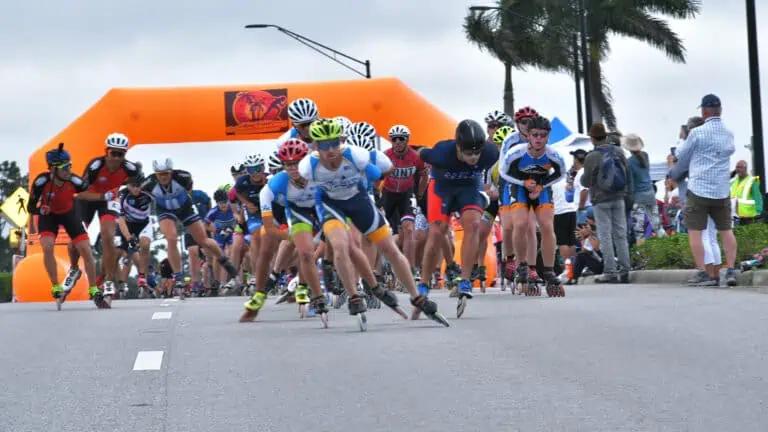a group of skaters proceed from the starting line of a marathon