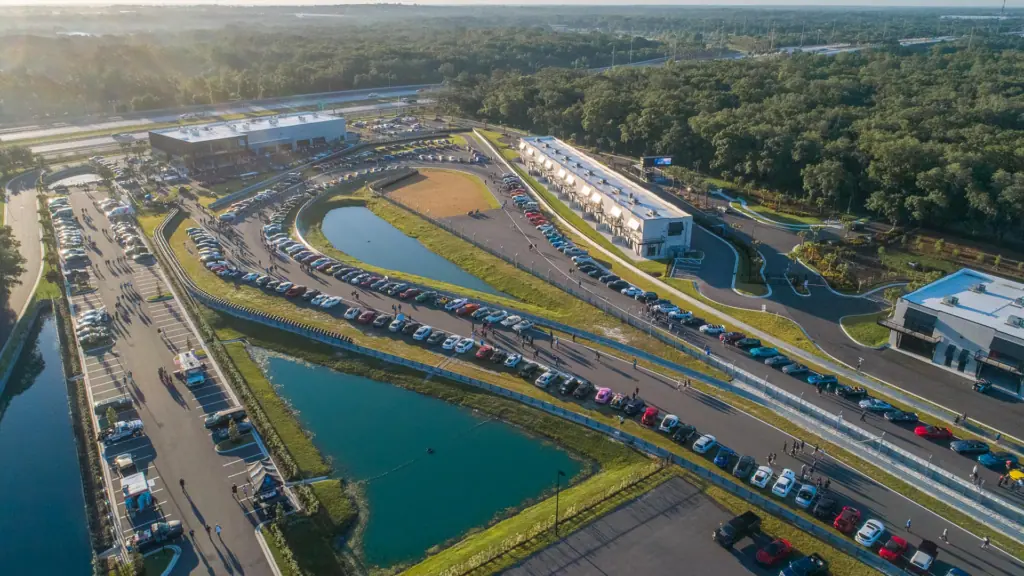 aerial view of a race track with multiple cars parked along the side