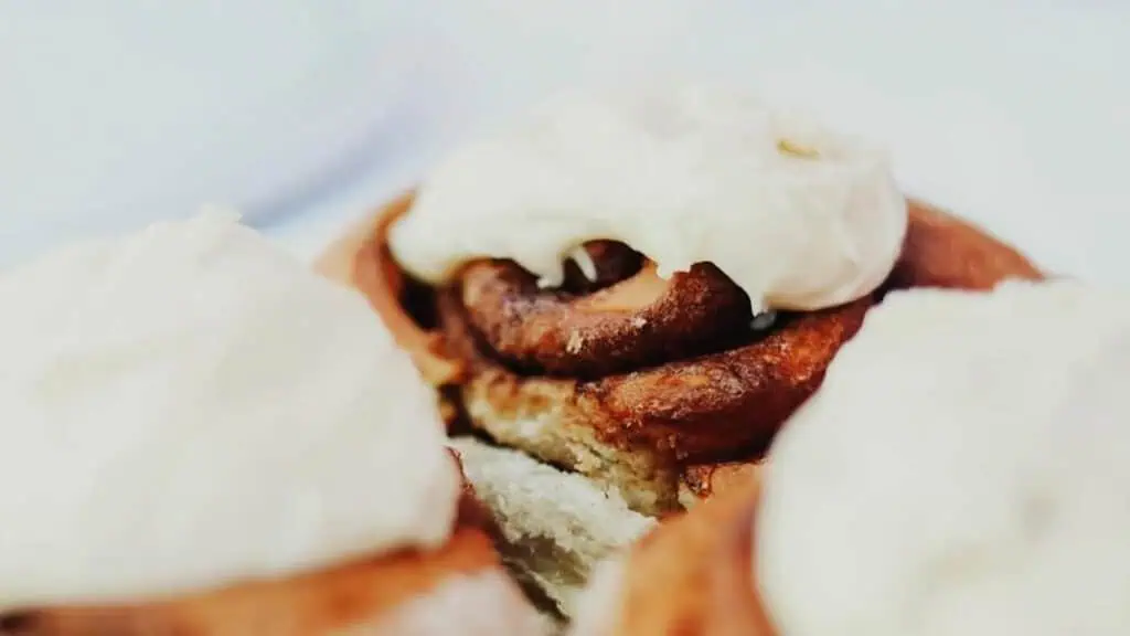 multiple cinnamon rolls covered in icing