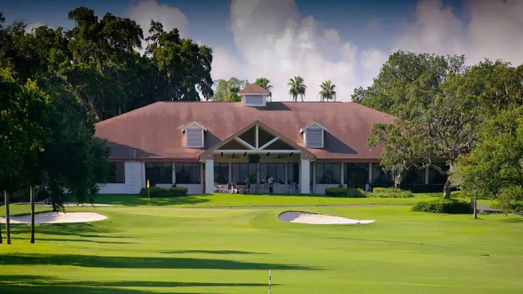 exterior of a country club with a golf course in the foreground