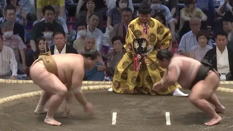 two sumo wrestlers prepare to face off in a match
