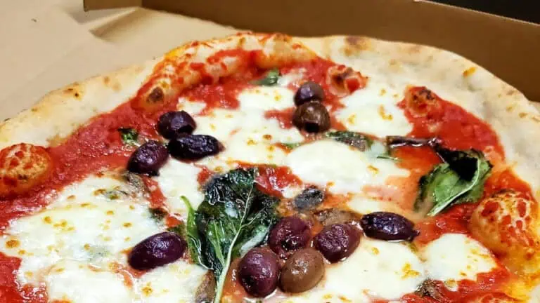 a pizza with black olives on a plate