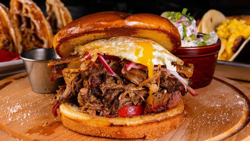 a big BBQ breakfast sandwich with a fried egg on top