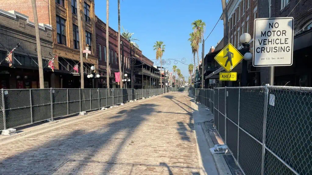 fencing up around new brick streets with palm trees in the background