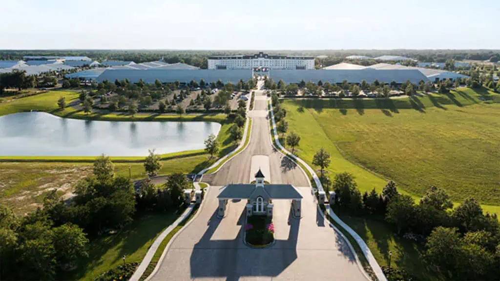 a long path toward a huge hotel with acres of green space surrounding it 