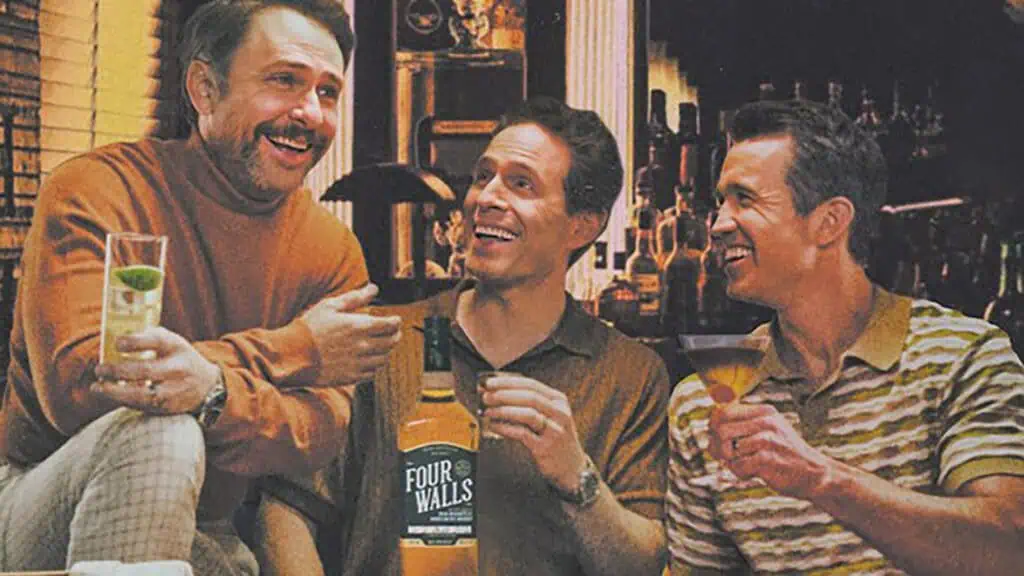 three men enjoy a glass of whiskey together