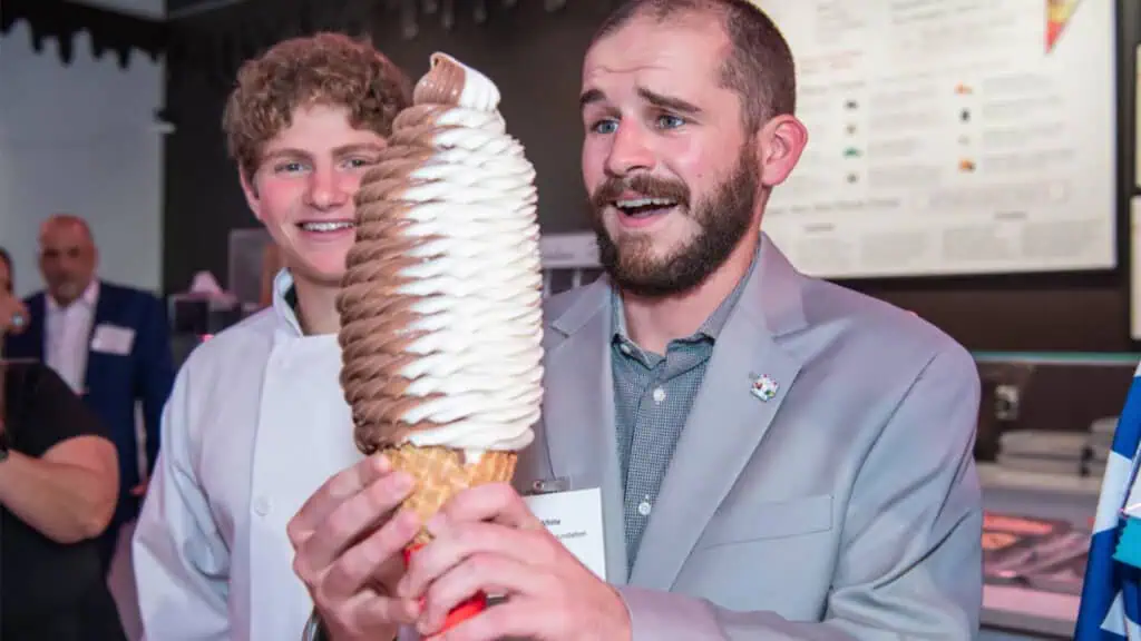 a man holds a giant ice cream cone