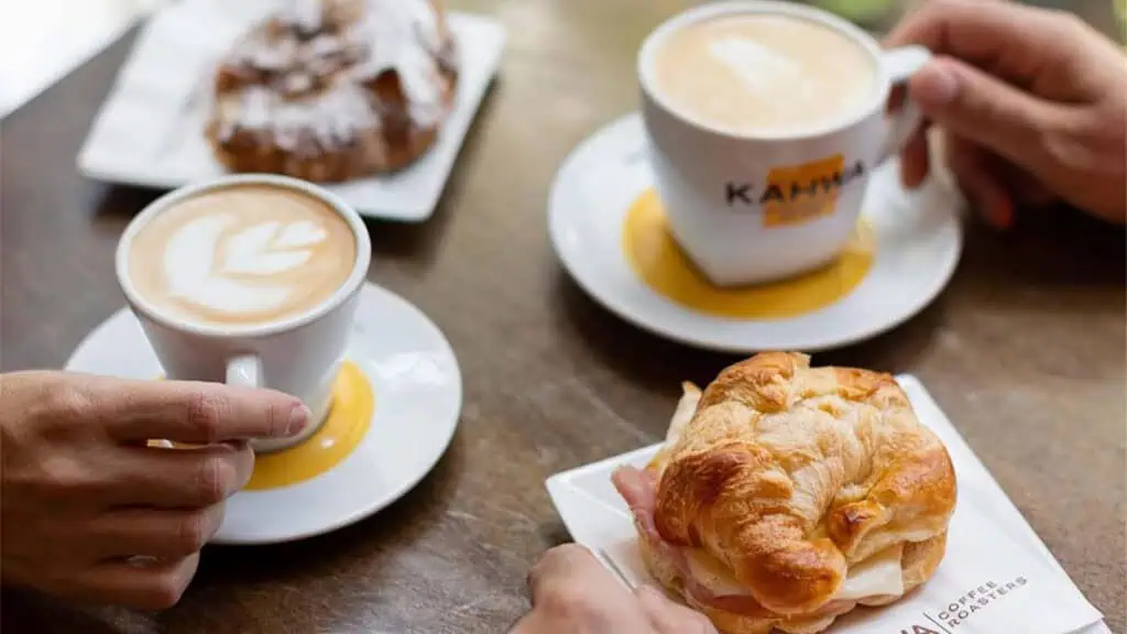 two lattes on a table with croissants 