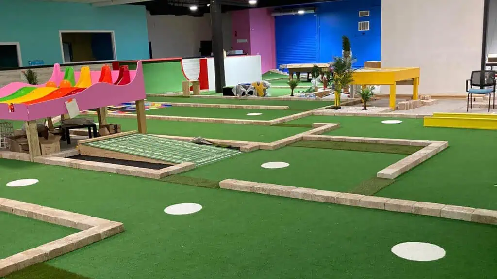 a mini golf course with multiple holes inside an indoor venue