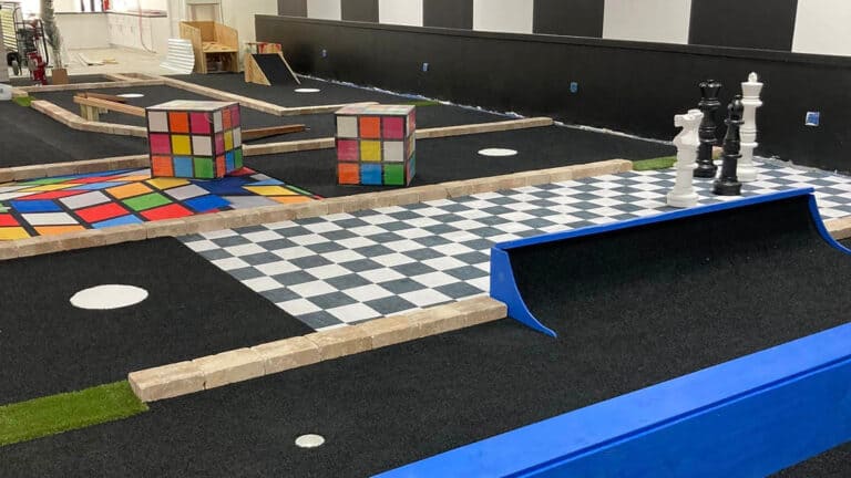 indoor mini golf venue with a green defined to look like a chess board