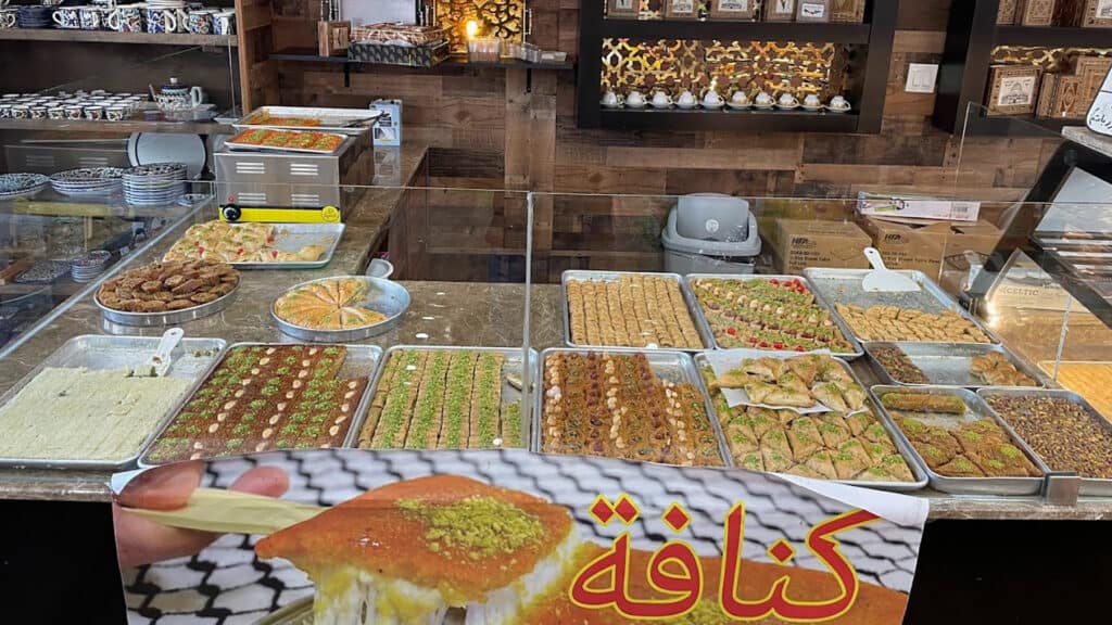 interior of a roastery and middle eastern market with multiple pastries on display. 