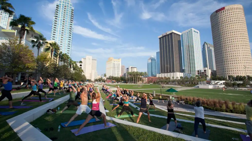 people participate in yoga in the park