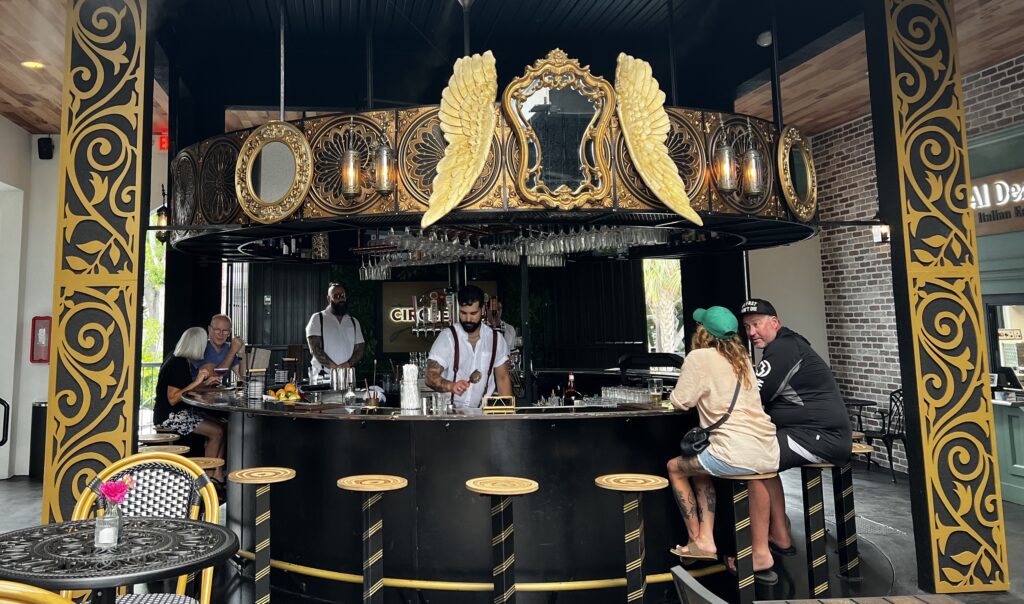 Carousel bar with two patrons and a bartender serving drinks.