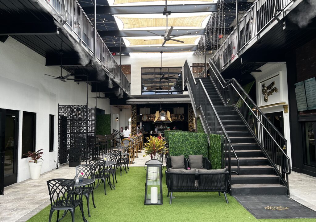 indoor courtyard, with tables, stairs, and shops.