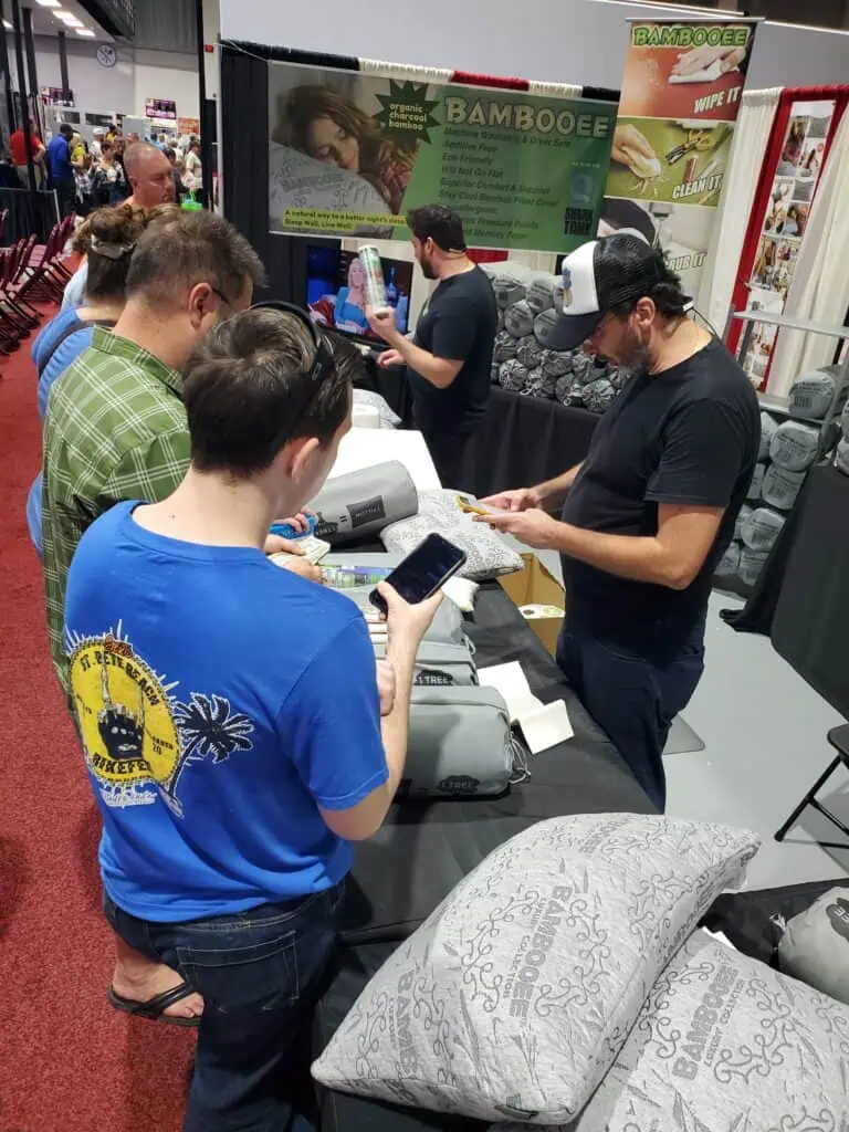 Two people looking at their phones in front of bedding