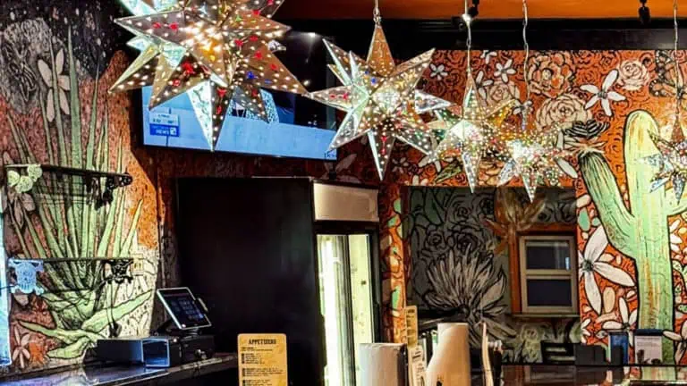 interior of a tequila bar with starry light fixtures and a western mural on the far wall