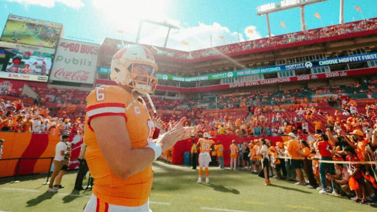 bright orange jersey on a QB at the center of a football field