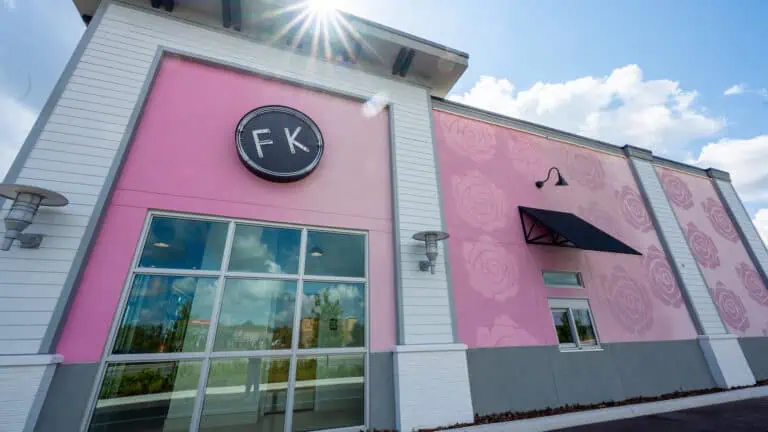 exterior of a pink building with a large black "FK" sign on the front.