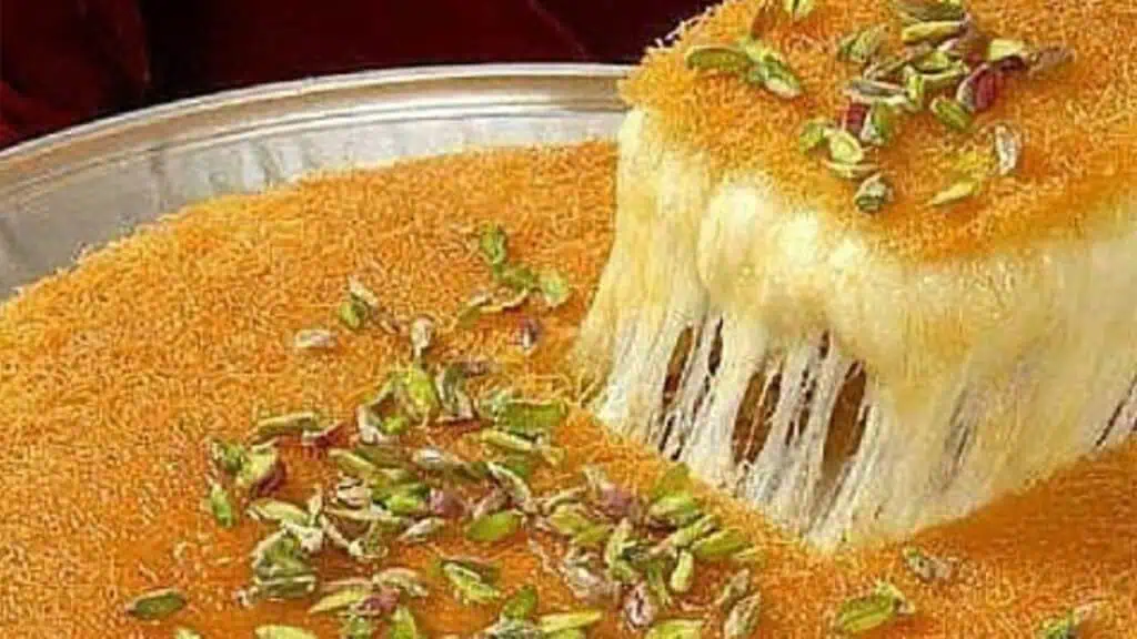 a plate of cheesy dessert being pulled from a pan