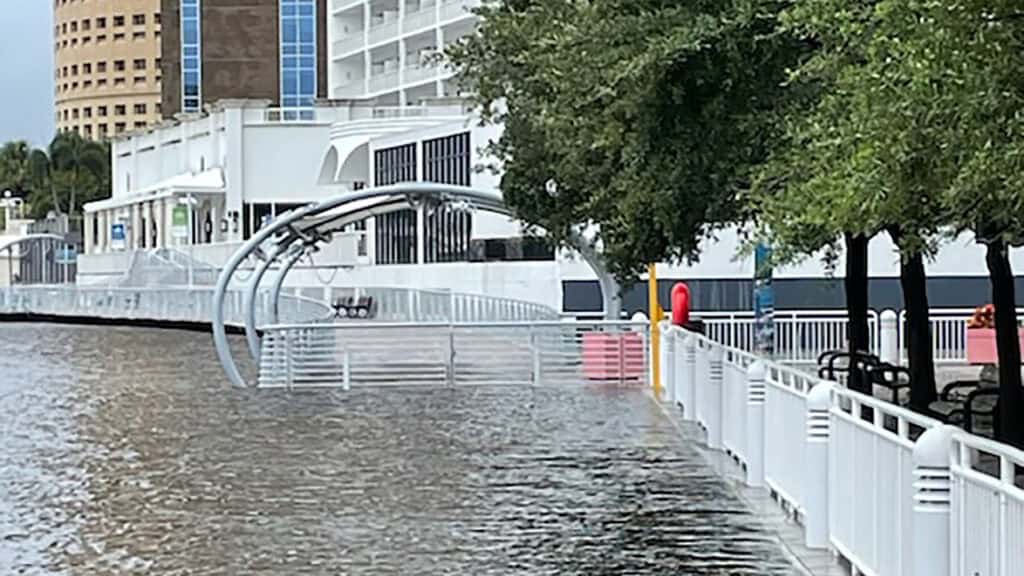 The Tampa Riverwalk begins to flood as the Hillsborough River rises over the walkway. 