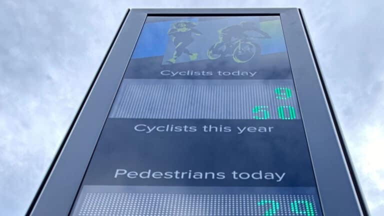 a large digital display board showing the number of pedestrians and cyclists on the road