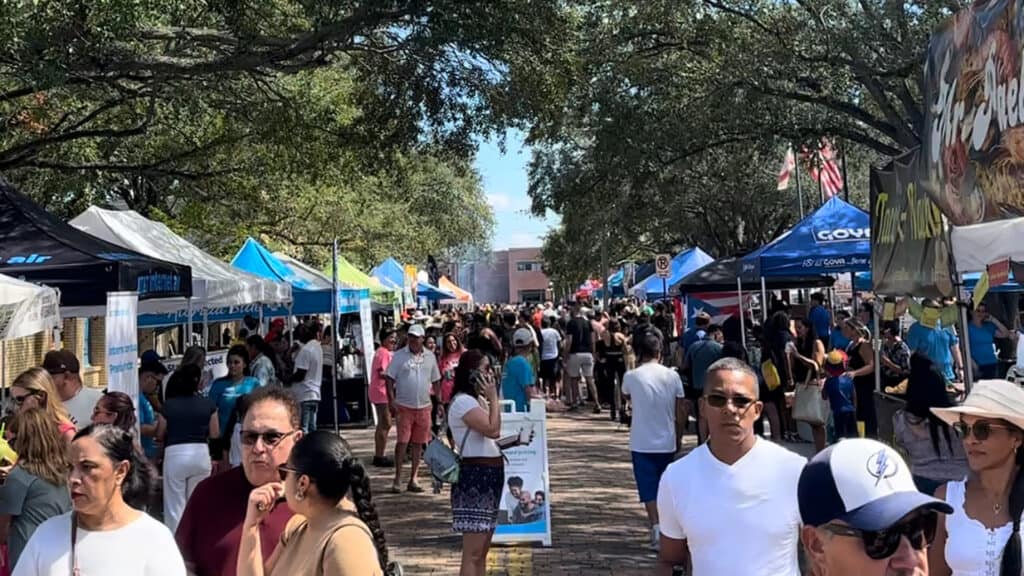 a street food festival with multiple vendors on a brick street