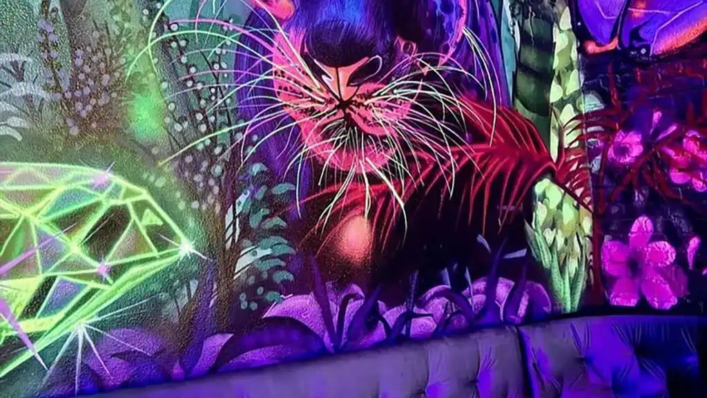 inside a restaurant and bar with neon paintings depicting animals