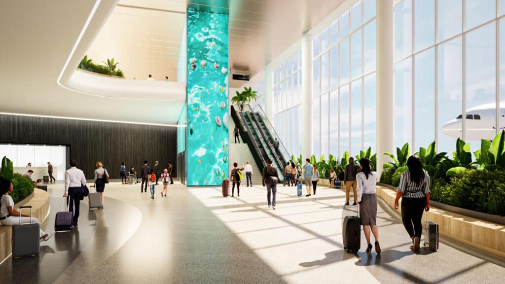 interior of an airport terminal with public art next to an escalator