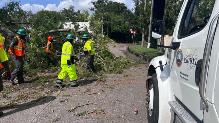 crews clean up debris in the street following a major storm