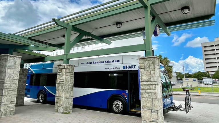 a bus pull into a station along a busy route