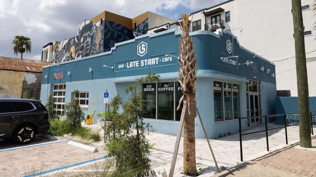 exterior of a burger shop with a blue facade and a white shell lawn area