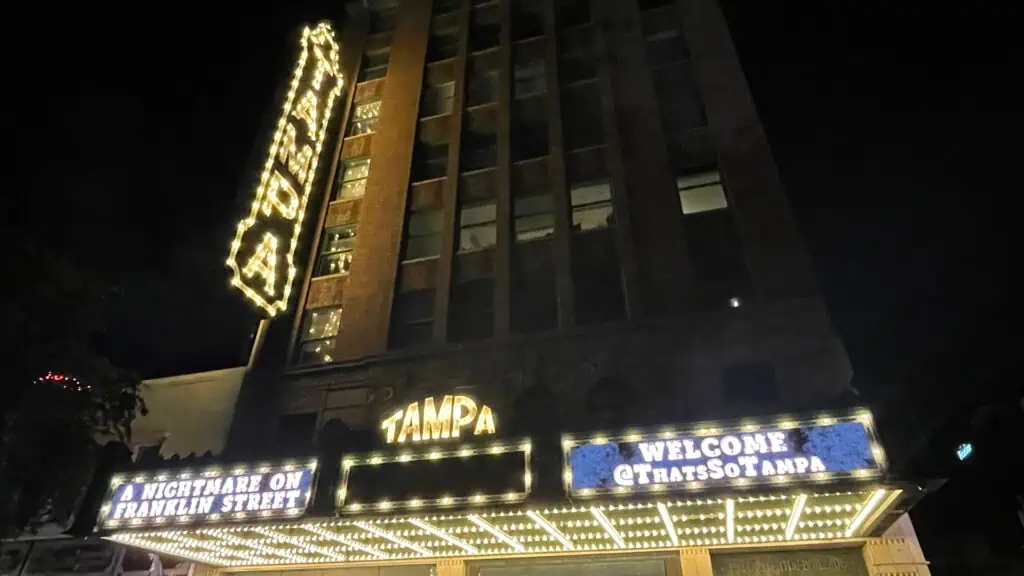 exterior of a movie theatre lit up at night