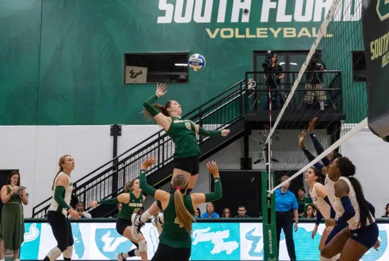 University of South Florida volleyball player jumps to spike the ball during a match.