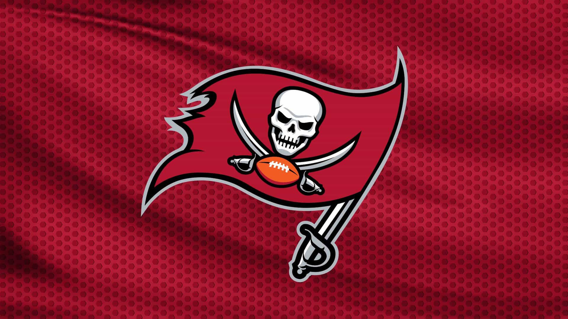 The Tampa Bay Buccaneers flag logo featuring a skull, crossed swords, and a football on a red, textured background.