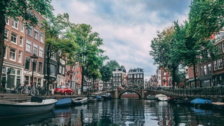 boats on a scenic river in Amsterdam. Historic buildings line the water way.