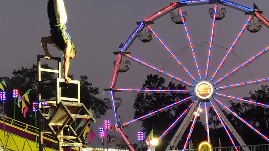 a gymnast does a hand stand on a stack of chairs