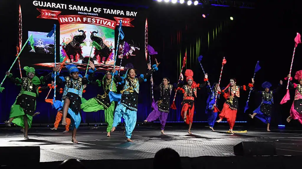 performers in bright costumes dance on stage 