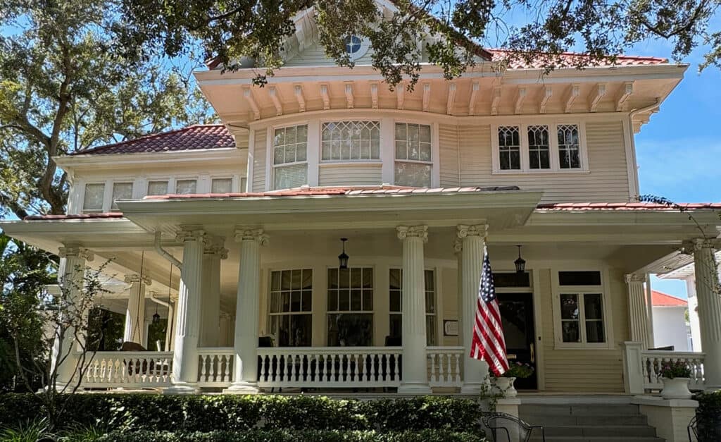 a historic home with a wrap around porch 