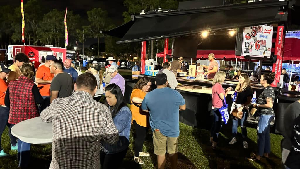 a group of people enjoying food vendors at an outdoor food event