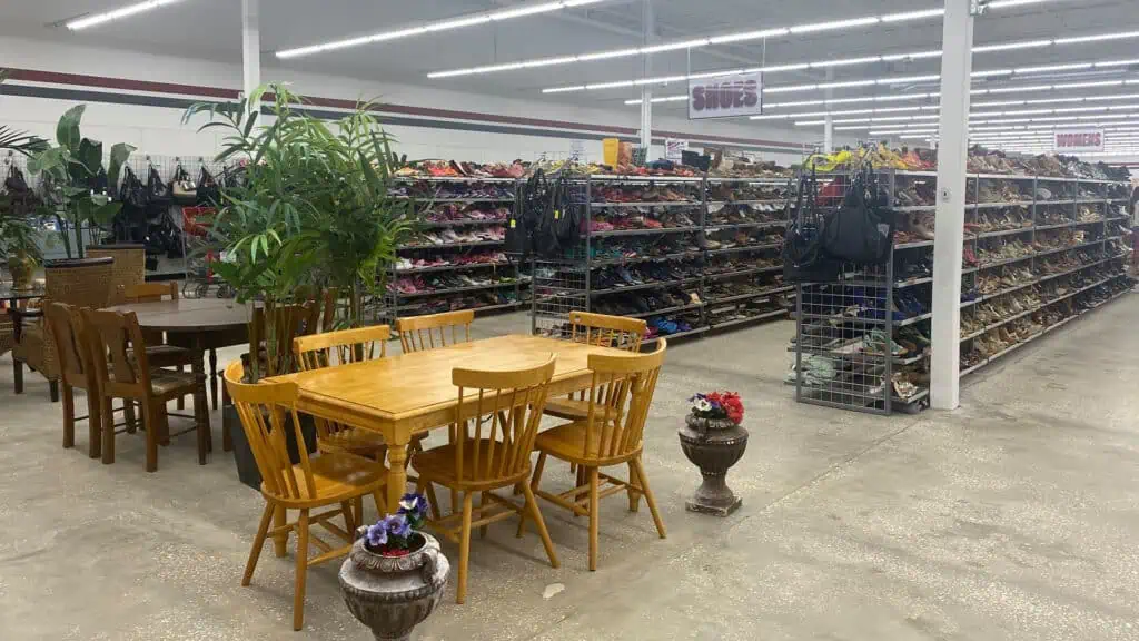 interior of a thrift shop with tables next to shoe racks