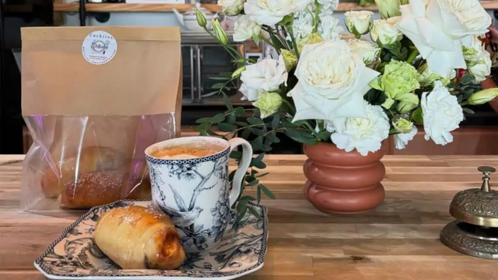 pastries arranged on a plate next to a bouquet of flowers 