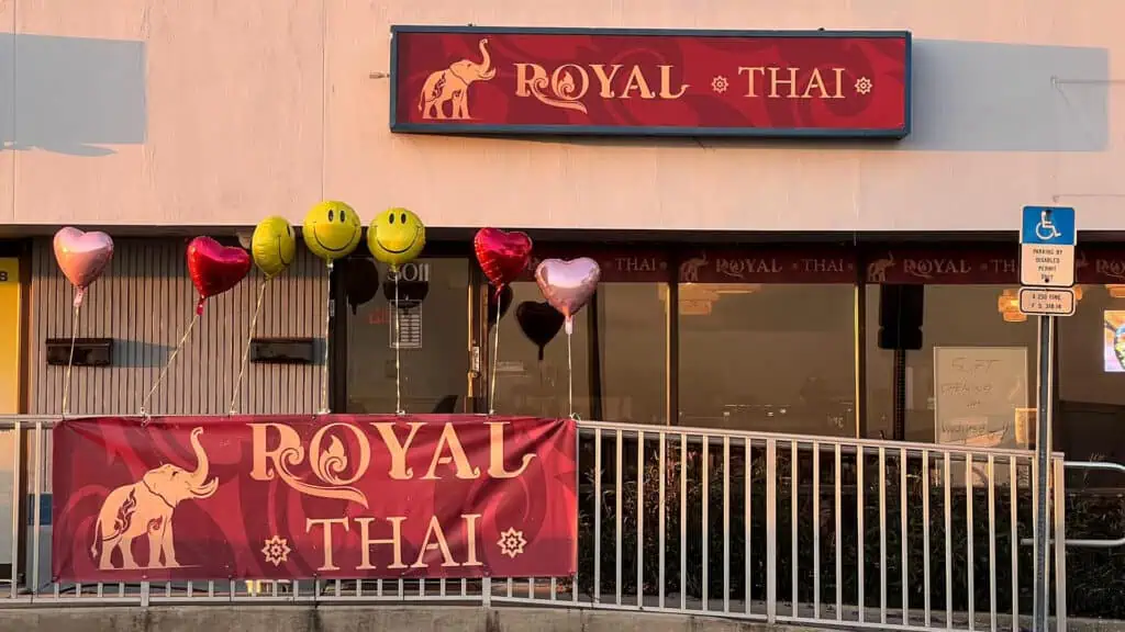 exterior of a Thai restaurant with a big red banner over the front 