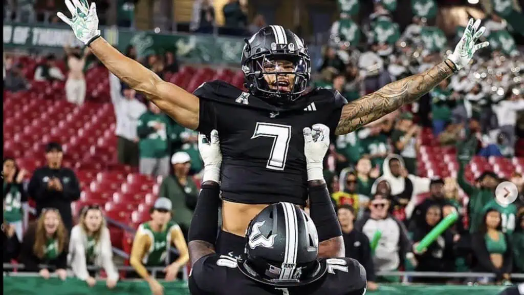 two football players celebrate on the field after a touchdown