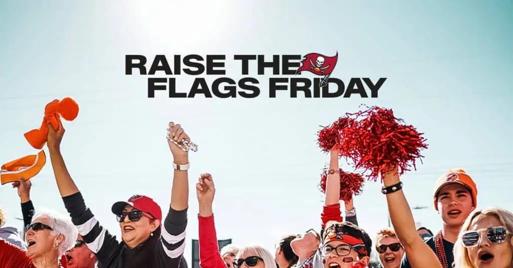 Fans cheer and wave pom-poms at a "Raise the Flags Friday" event, celebrating the Tampa Bay Buccaneers.