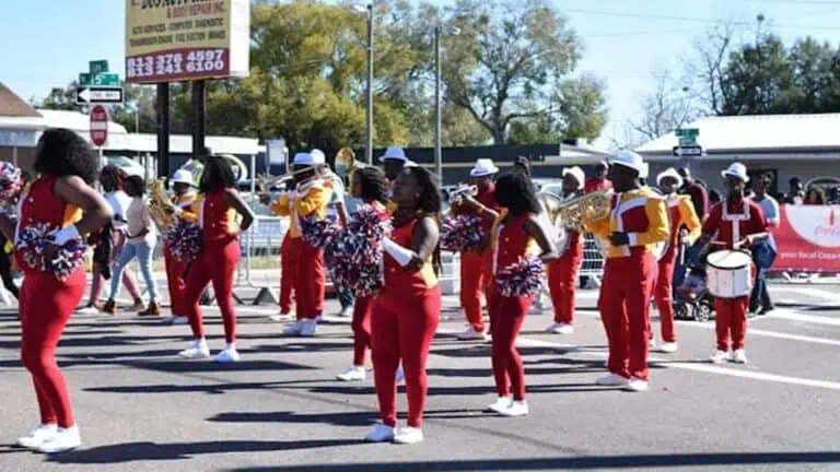 a marching band in a red uniform performs in the street