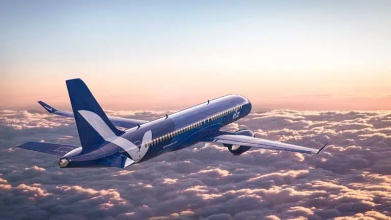 a plane hovers above the clouds around sunrise