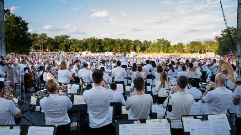 Orchestra playing on stage in a park