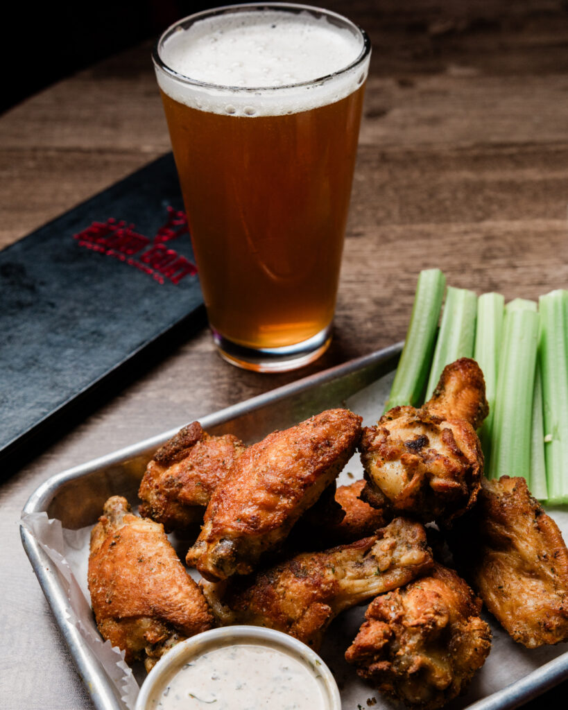 A person eating wings at Blind Goat in Tampa