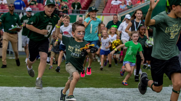 kids wearing USF merch running on a field